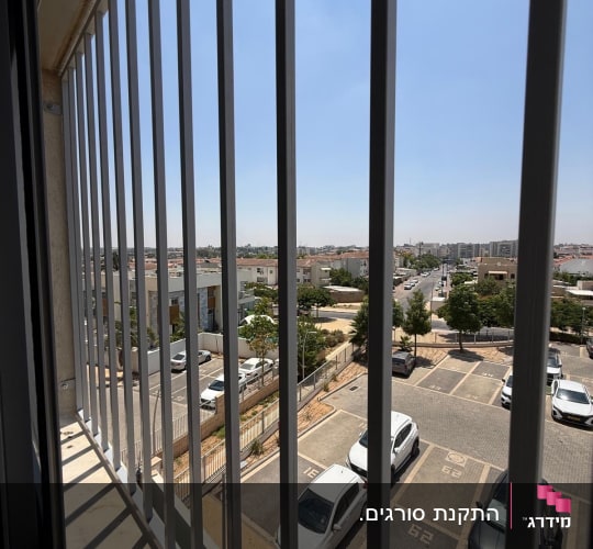 סורגים ישרים ממתכת מותקנים בחלון דירה בקומה גבוהה